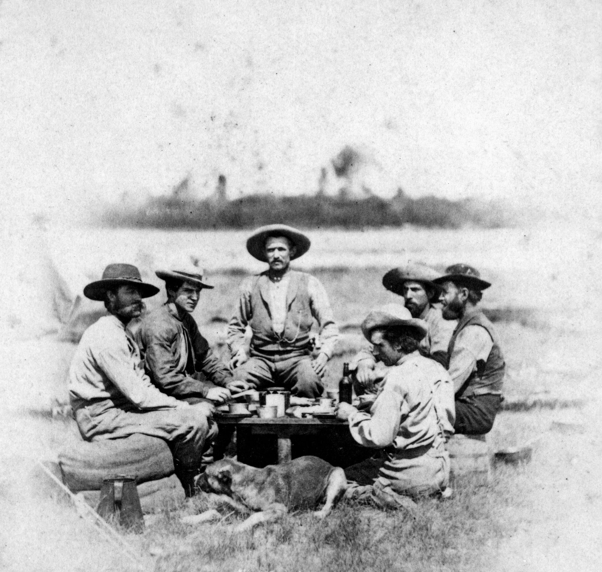 Men sit around a campfire